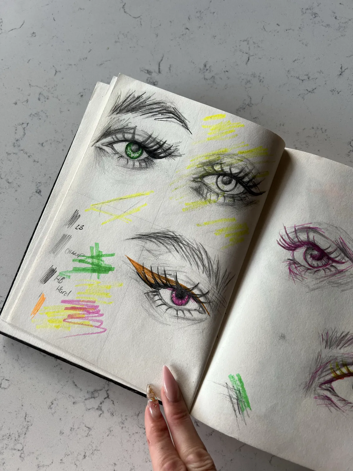 Sketchbook page of eye studies with bright color swatches