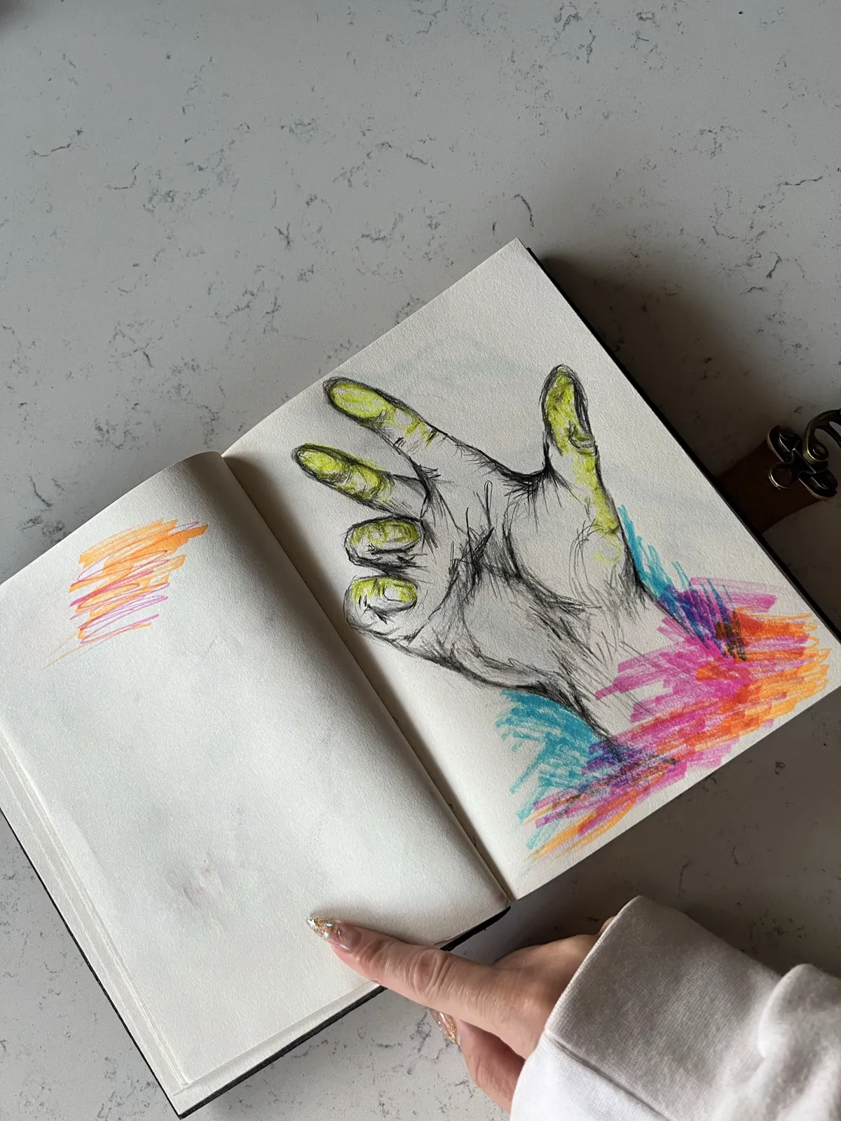 Sketchbook drawing of a hand with neon color strokes
