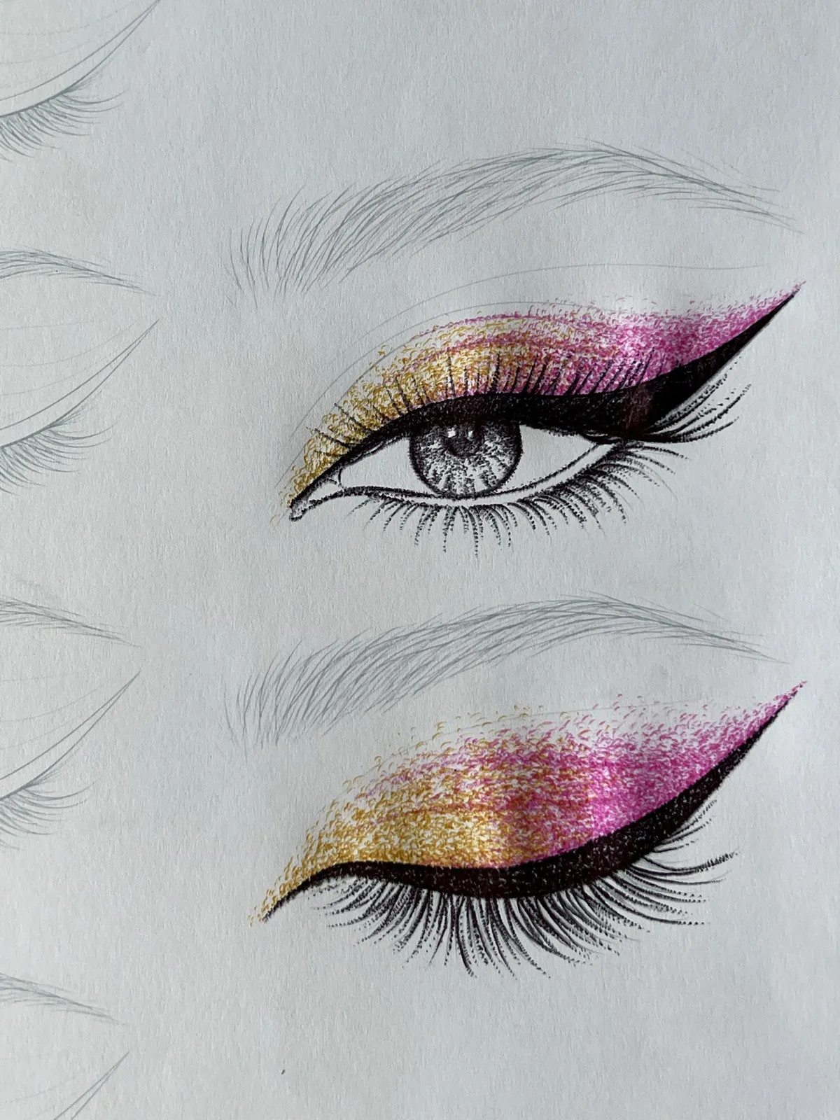 Two eyes with gold and pink glitter wing liner on a face chart