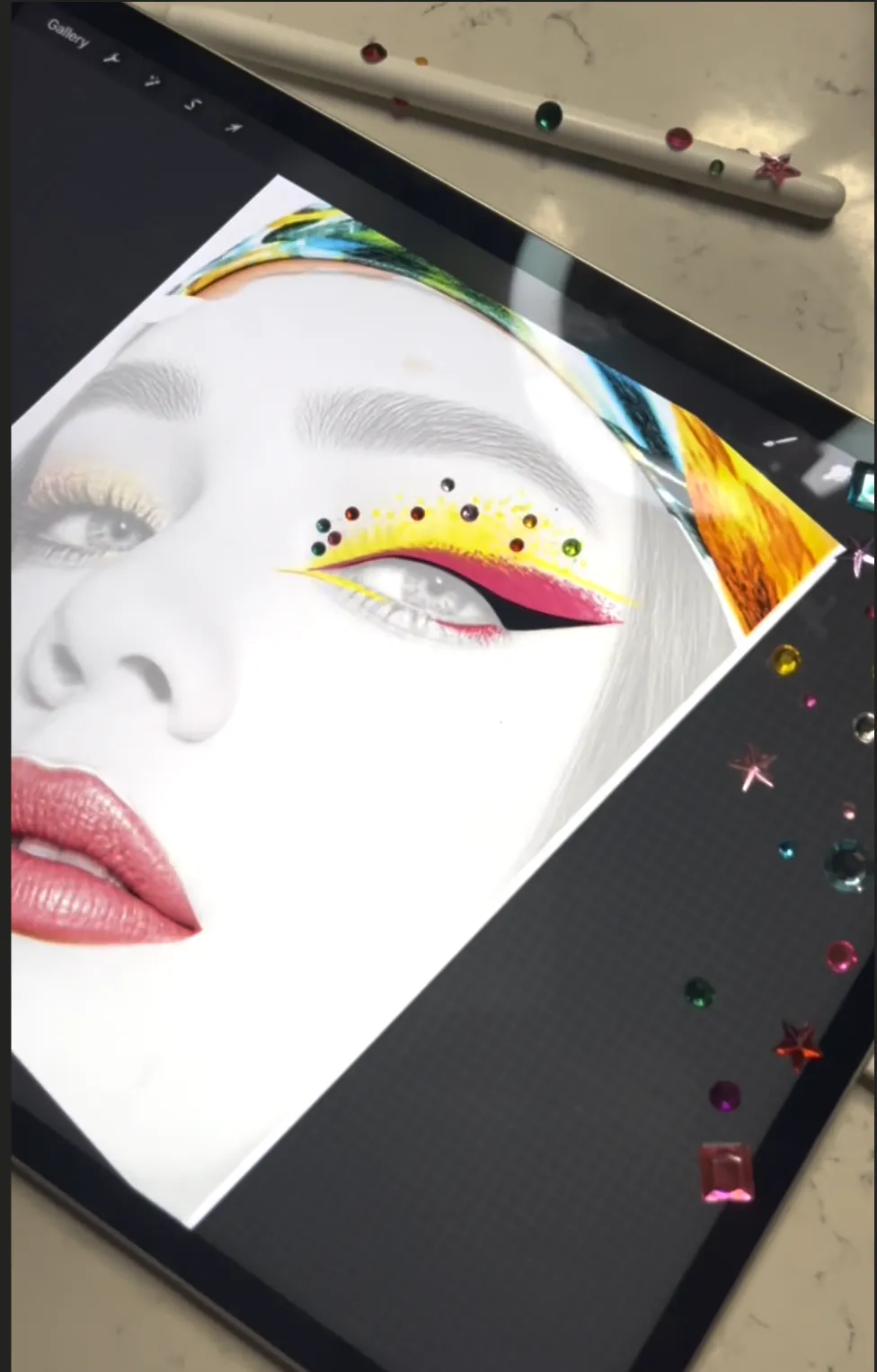 Procreate on the iPad: a face with yellow and pink graphic liner, gems scattered along the screen