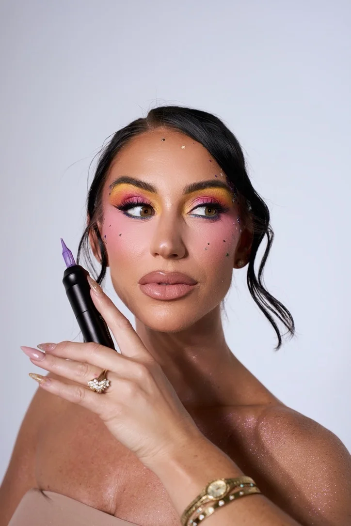 Portrait of Taylor holding the Astera with a purple needle cartridge